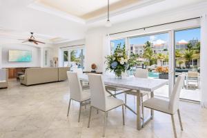 a dining room with a white table and chairs at Salt Life Villa in Long Bay Hills