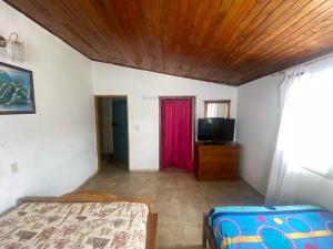 1 dormitorio con 1 cama y TV de pantalla plana en Tahamies Hostal - Artesanos y Turistas., en Guatapé