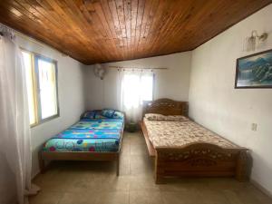 una camera con due letti e una finestra di Tahamies Hostal - Artesanos y Turistas. a Guatapé