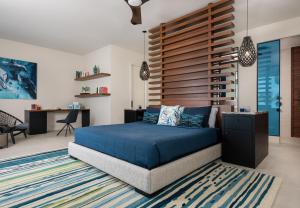 a bedroom with a blue bed with a wooden wall at Clevelander in Long Bay Hills