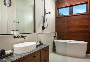 a bathroom with a tub and a sink and a mirror at Clevelander in Long Bay Hills