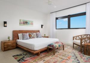 a bedroom with a bed and a chair and a window at Clevelander in Long Bay Hills