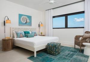 a white bedroom with a bed and a window at Clevelander in Long Bay Hills