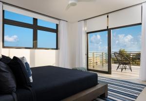 a bedroom with a bed and sliding glass doors at Clevelander in Long Bay Hills +37 photos