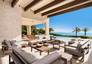 an outdoor patio with furniture and a view of the ocean at Clevelander in Long Bay Hills