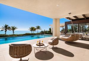 a living room with a pool and chairs and a table at Clevelander in Long Bay Hills
