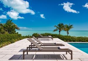 a row of lounge chairs next to a swimming pool at Clevelander in Long Bay Hills