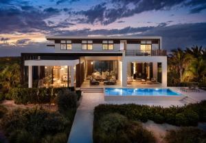 a house with a swimming pool at dusk at Clevelander in Long Bay Hills