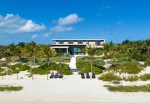 a house on the beach with palm trees at Clevelander in Long Bay Hills