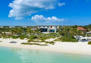a house on the beach next to the ocean at Clevelander in Long Bay Hills