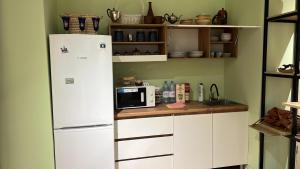 uma cozinha com armários brancos e um frigorífico branco em Friends Hostel em Astana