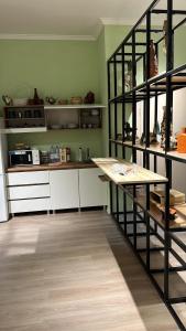 uma cozinha com armários brancos e uma prateleira preta em Friends Hostel em Astana