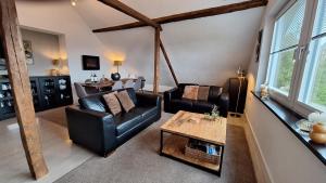 a living room with two leather chairs and a table at Group Haus Blick am Edersee 13P in Waldeck