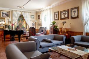 a living room with couches and a table and a piano at Nyerges Hotel Termál Superior in Monor