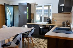 a kitchen with a sink and a table with chairs at La Flémingîte in Scionzier