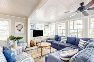 a living room with a blue couch and a tv at Aloha Friday in Edisto Island