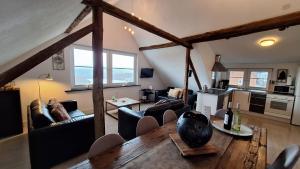 a living room with a table and couches and a kitchen at Group Haus Blick am Edersee 13P in Waldeck