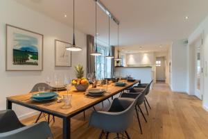 a dining room with a long wooden table and chairs at Reetdachhaus-Hoher-Himmel in Sankt Peter-Ording