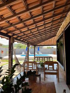 een paviljoen met stoelen, een tafel en een televisie bij Casa Canto da Serra in Búzios