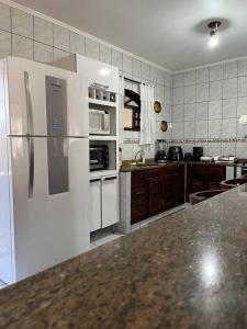 a kitchen with a white refrigerator and a counter top at Casa Canto da Serra in Búzios