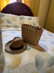 a hat and a basket on a bed at Casa Canto da Serra in Búzios