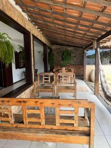 a porch with a wooden bench on a patio at Casa Canto da Serra in Búzios