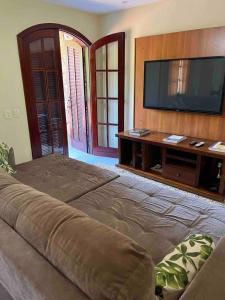 uma ampla sala de estar com uma televisão de ecrã plano em Casa Canto da Serra em Búzios