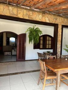 eine Terrasse mit einem Tisch und Stühlen sowie ein Haus in der Unterkunft Casa Canto da Serra in Búzios