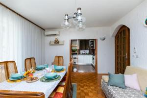 a dining room with a table and a couch at Apartment VESNA in Pinezici