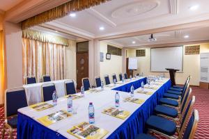 una sala conferenze con tavoli lunghi, sedie e schermo di Charleston Hotel a Accra