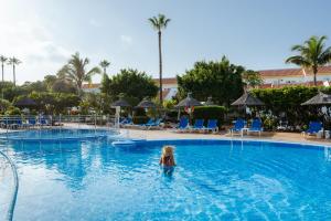 a little girl in the water at a swimming pool at Wyndham Residences Golf del Sur in San Miguel de Abona