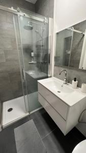 y baño con lavabo blanco y ducha. en Studio chic proche aéroport & centre-ville, en Charleroi