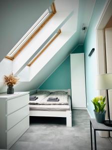 łóżko w pokoju z niebieską ścianą w obiekcie Coast House 25 -TRZĘSACZ SUNNY SIDE BALTIC w Trzęsaczu