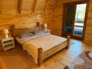 a bedroom with a bed in a log cabin at Vikendica Krupa na Vrbasu in Banja Luka