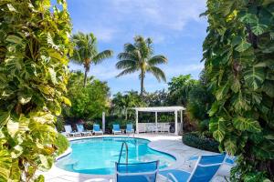 a pool with chairs and a gazebo and palm trees at Carpe Diem 3 BR Condo in The Bight Settlements