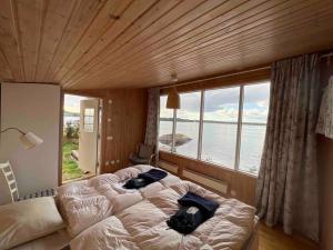 a large bed in a room with a large window at "Talludden" by the lake Årydssjön, in Furuby