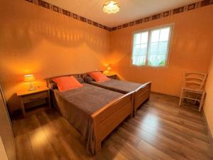 a bedroom with a bed and two tables and a window at Chez estecahandy in Esquiule