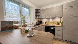 a kitchen with stainless steel appliances and a wooden table at Duenenhuus in Sankt Peter-Ording