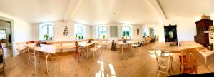 a large room with tables and chairs and windows at Brandstatthof - Hotel und Restaurant in Steingaden