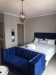 Sofá azul en una habitación con cama en Budget-Friendly & Cozy Haven by BK Hospitable, en Midrand
