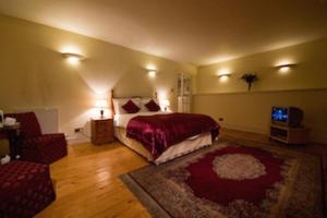 a bedroom with a bed and a couch and a television at The Ben Doran Guest House in Edinburgh