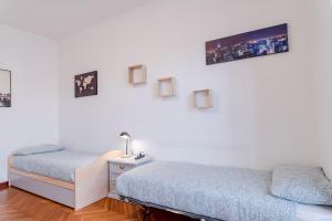 Student's Home في تورينو: غرفة نوم بسريرين وتلفزيون على الحائط