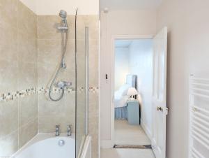 a bathroom with a shower and a bath tub at Thorney Road in Emsworth