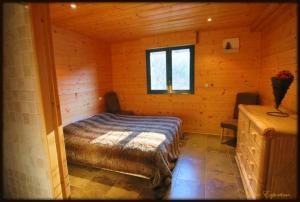 1 dormitorio con 1 cama en una cabaña de madera en High standing chalet / SPA overlooking the valley en Eyne