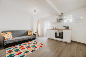 a living room with a couch and a kitchen at Aloha Surf House in Ericeira