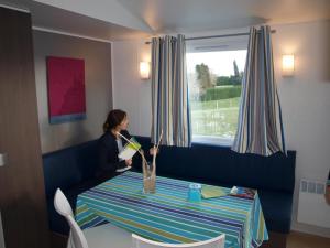 a woman is sitting at a table with a vase at Le colvert in Orist