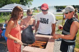 a group of people cooking hot dogs on a grill at Le colvert in Orist