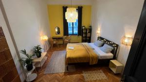 1 dormitorio con 1 cama con colcha amarilla en NAPartman Pécs, en Pécs