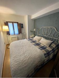 a bedroom with a large bed with a blue and white blanket at Casa Paci 