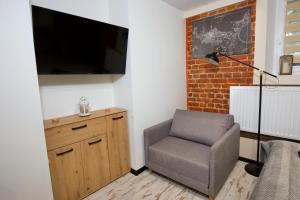 un soggiorno con sedia e TV di LOFTY CHOPINA a Bydgoszcz